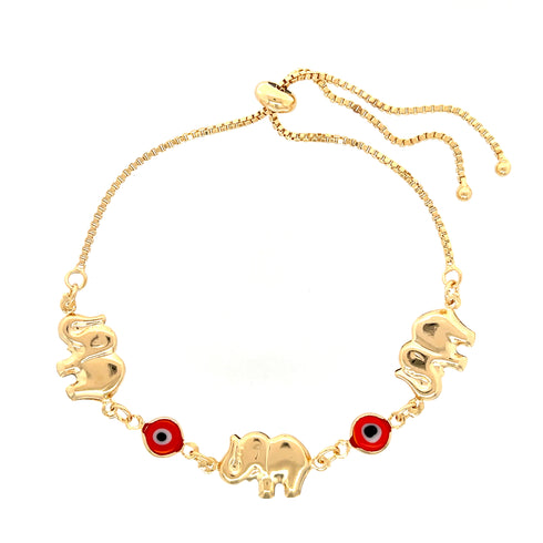 The "Red Evil Eye Elephant Charm Bracelet" is crafted from 14k gold-filled material and features three elephant-shaped charms alongside two vivid red-and-blue circular charms, including an evil eye charm. Its adjustable chain with two dangling ends enhances its elegance.